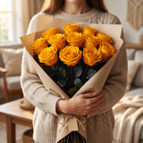 Woman holding a wrapped bouquet of yellow long stem preserved roses